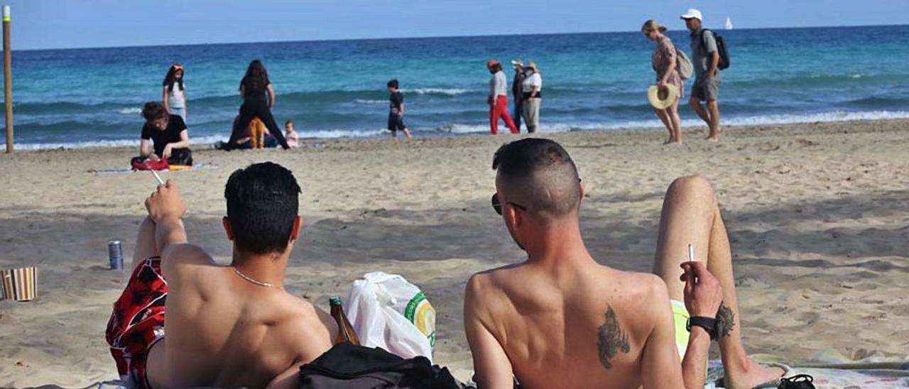 Dos jóvenes fuman en la playa del Postiguet, en una imagen tomada este jueves. | PILAR CORTÉS