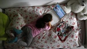 Una niña de 12 años navega en redes sociales desde la habitación de su casa.