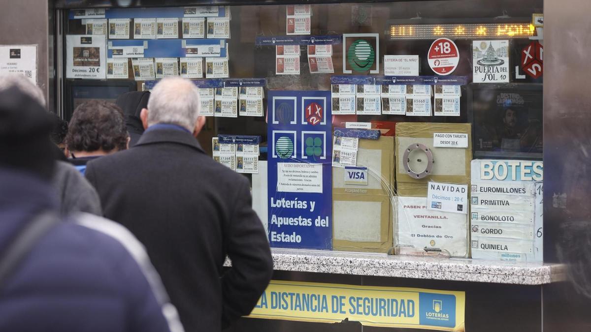 Varias personas en una administración de lotería de Navidad de la Puerta del Sol cuando quedan menos de tres semanas para el Sorteo Extraordinario de la Lotería de Navidad, a 7 de diciembre de 2021, en Madrid (España). Como cada año, la Lotería de Navidad