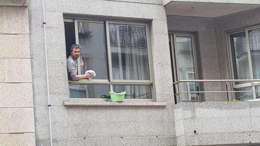 Un vecino de Cangas aprovecha la jornada de ayer para limpiar las ventanas de su domicilio. // G.N.
