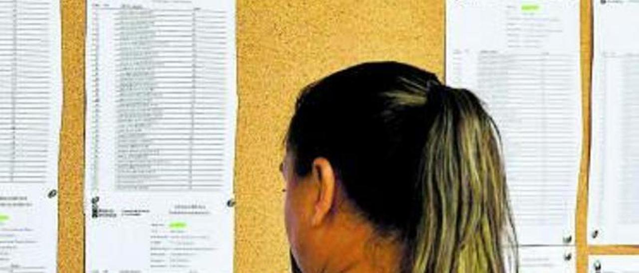 Una aspirante a una plaza pública mira las listas de los exámenes. | |