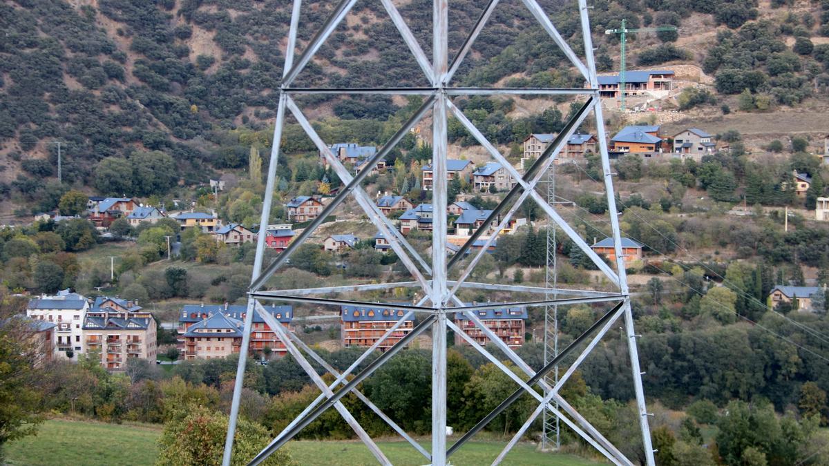 Primer pla d&#039;un tros de torre elèctrica. Al fons cases d&#039;una urbanització de Sort