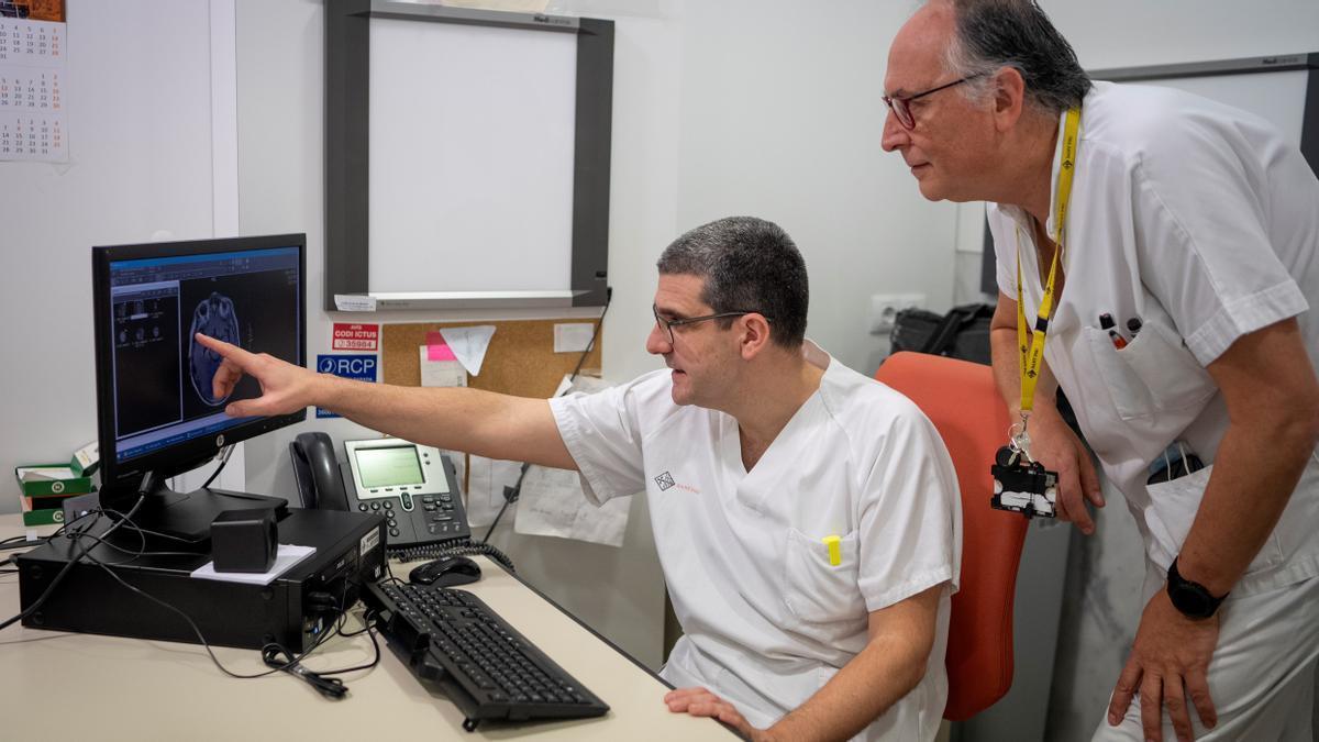 Un neurólogo y un enfermero del Servicio de Neurología del Hospital de Sant Pau observan la imagen del cerebro.