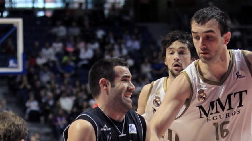 El pívot bosnio del Real Madrid Mirza Begic (d) disputa un balón con el base del CAI Zaragoza Carlos Cabezas.