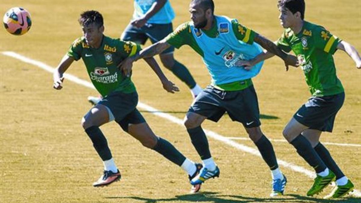 Intensidad 8Neymar, Alves y Óscar pugnan en el entrenamiento de ayer de Brasil.