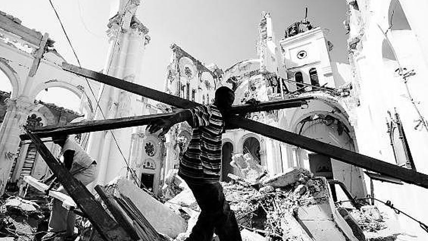 Unos hombres recogen restos entre las ruinas de la catedral de Puerto Príncipe.