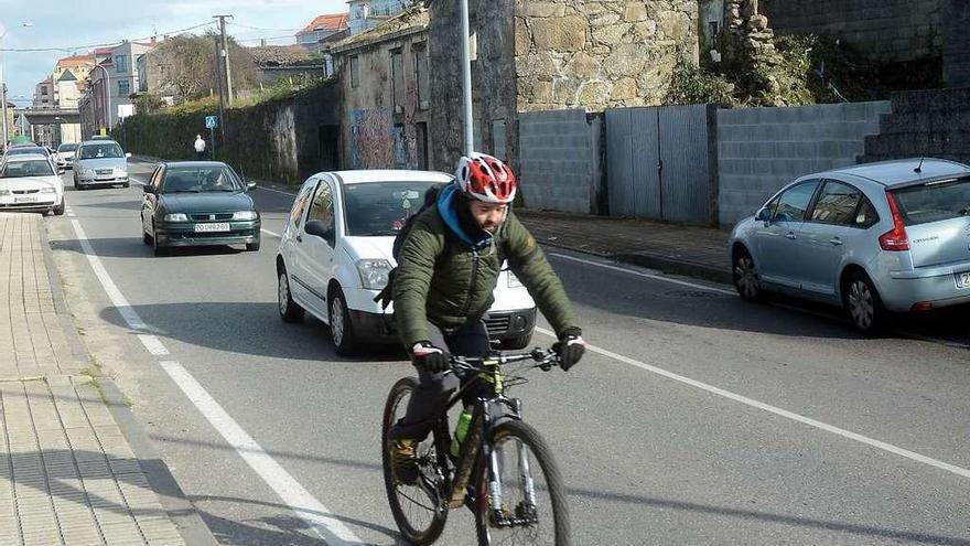 Un ciclista circula por la PO-546, en el tramo de Rosalía de Castro. // Rafa Vázquez