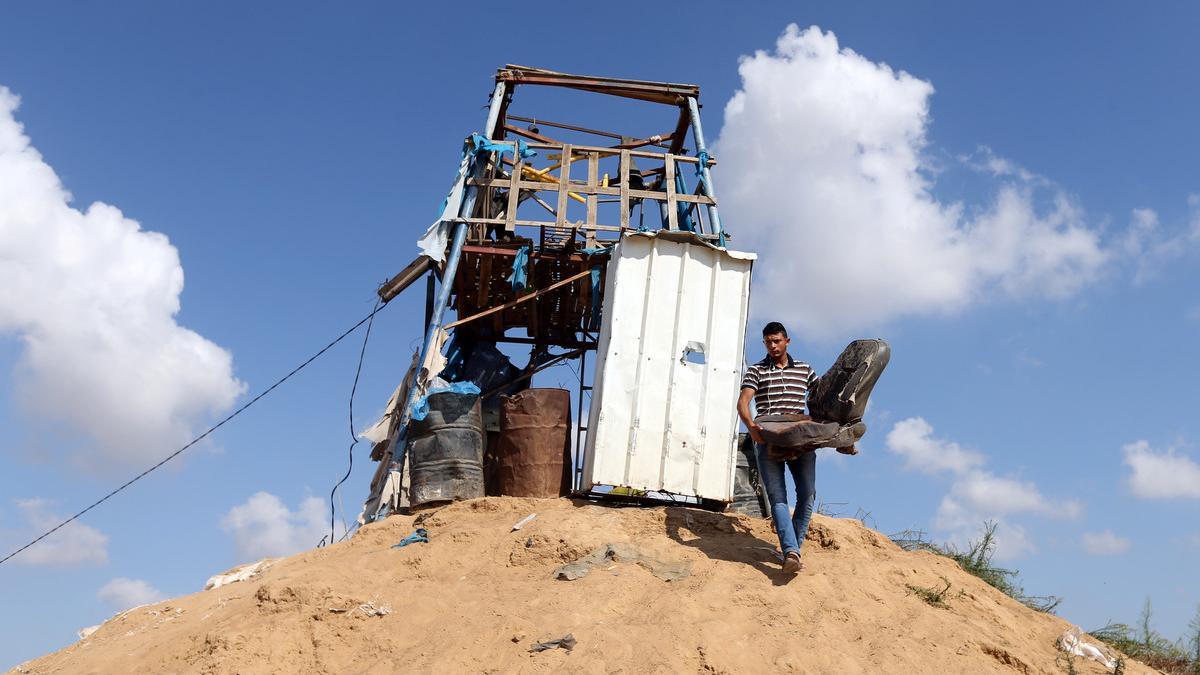 Palestinian man removes a chair at a Hamas observation post that was targeted in Israeli shelling, in Khan Younis in the southern Gaza Strip