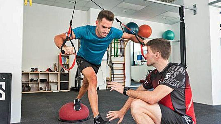 L&#039;entrenador personal Albert Pascual ajuda un esportista en un exercici