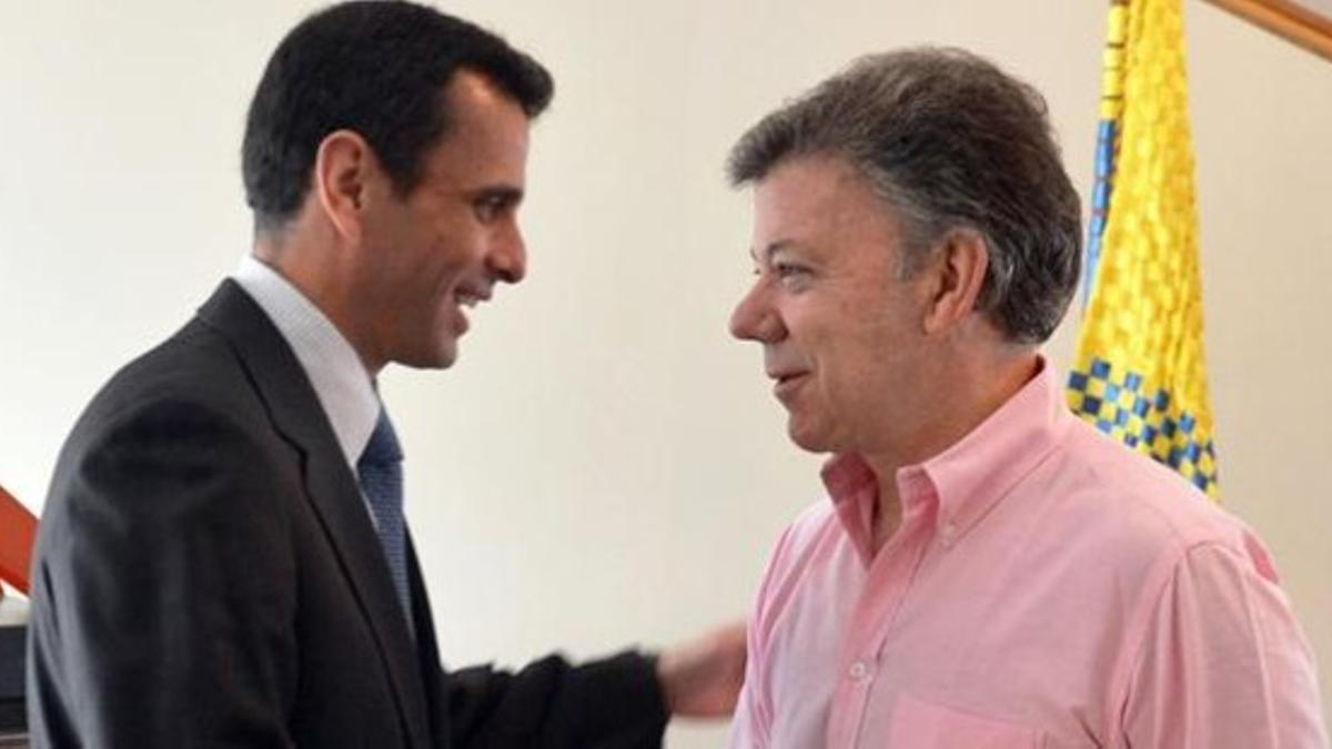 Capriles, izquierda, es recibido por el presidente colombiano.