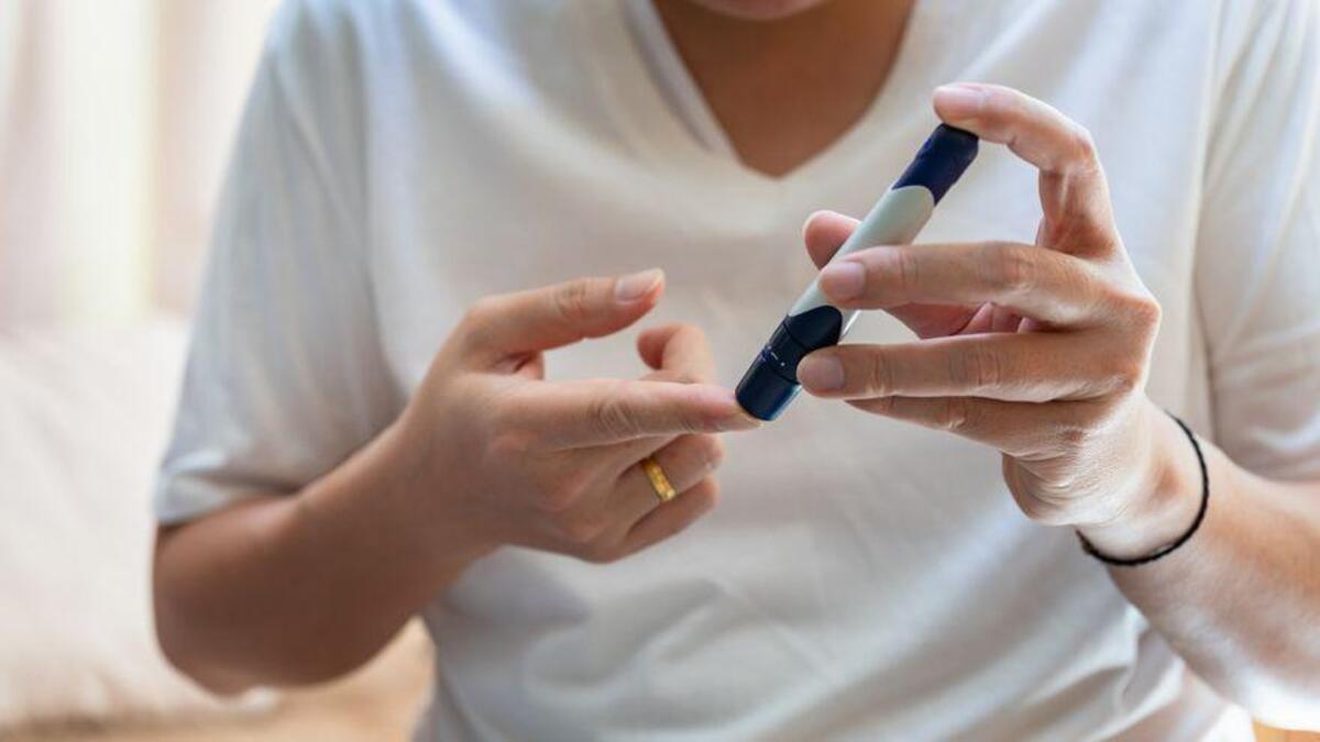 Una diabética se extrae una muestra de sangre para medir sus niveles de glucosa.