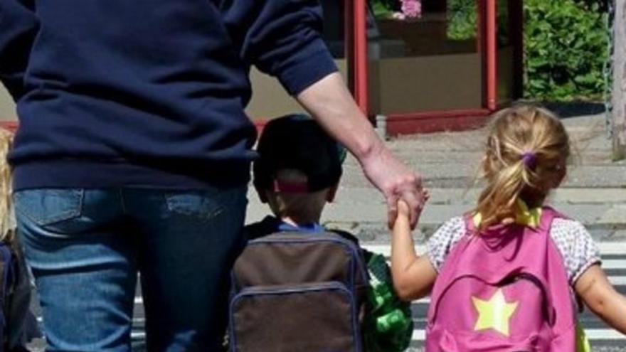 Imagen de archivo de un padre que lleva a sus hijos a la escuela. |   // LOC