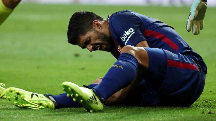 Suárez se duele durante el partido ante el Real Madrid. // Efe