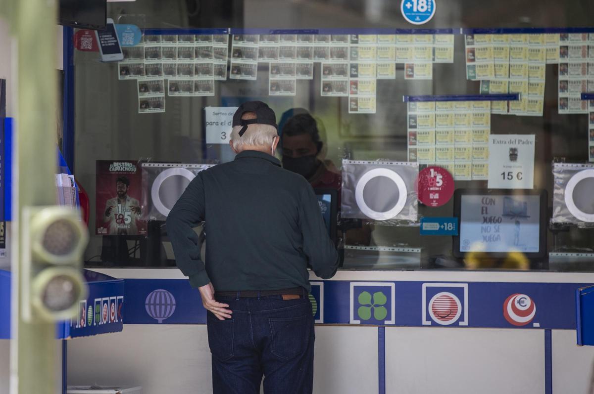 Archivo - Dos personas compran lotería en una Administración durante el primer día del proceso de desescalada instaurado por el Gobierno en el que los sorteos de EuroMillones y La Primitiva se reanudan en la semana del 18 al 24 de mayo, mientras que los d