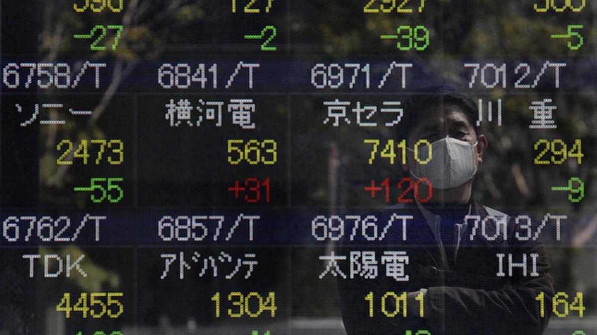 Un hombre se refleja en un panel que registra la evolución de los valores bursátiles de la Bolsa de Tokio, este jueves.