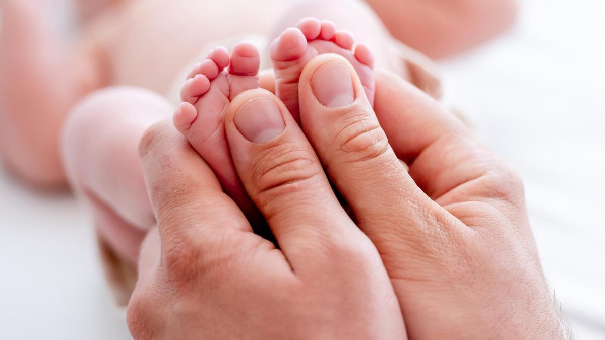 Una madre sosteniendo los pies de su recién nacido