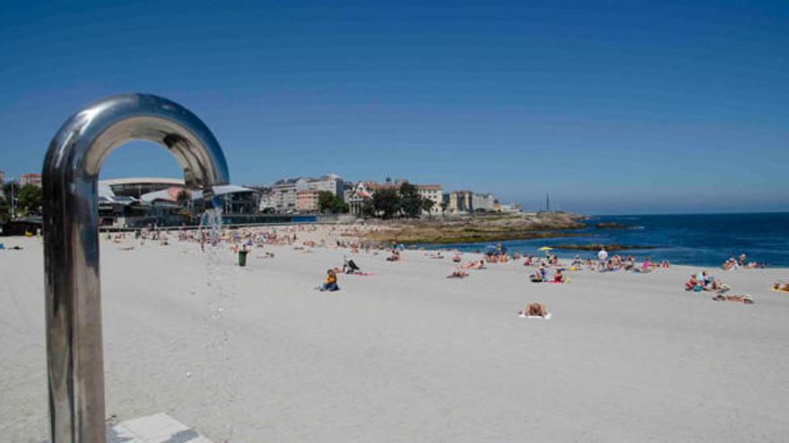 Algunos bañistas en la playa de Riazor.