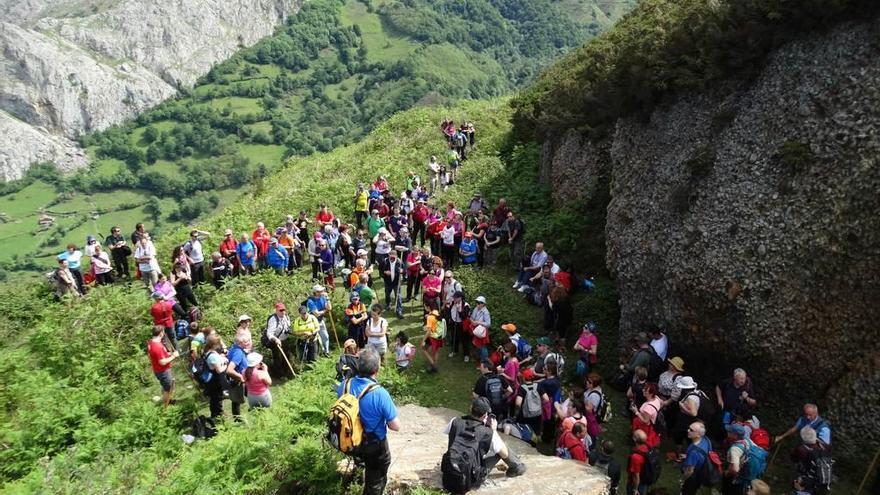 Los senderistas atienden las explicaciones de los guías en La Muezca de la Pudinga durante la ruta realizada el pasado 21 de mayo. Al fondo, Collado Plano, lugar que será punto de encuentro el domingo.