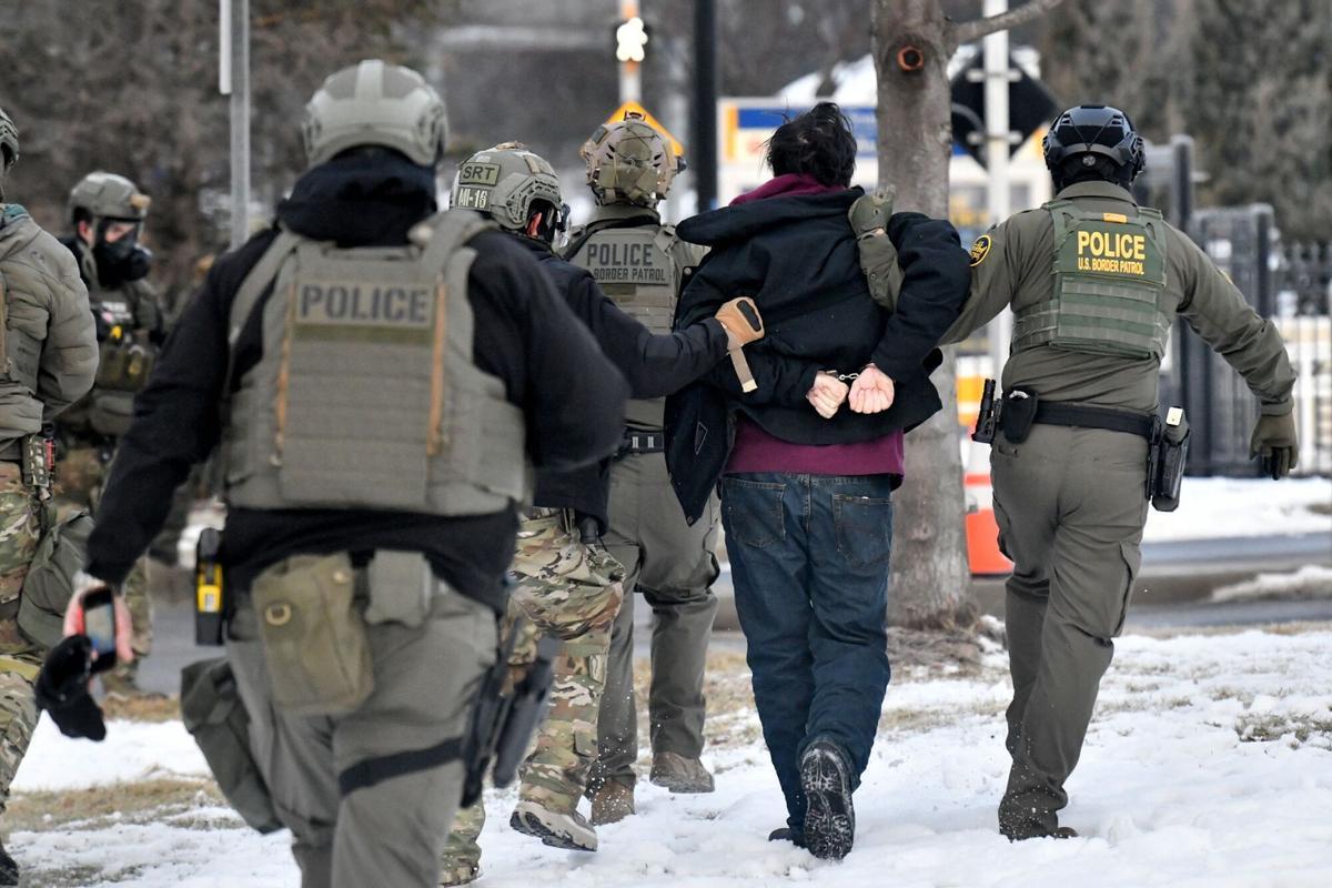 Federal agents detain a man as protestors demonstrate outside the Bishop Henry Whipple Federal Building in Saint Paul, Minnesota, on January 8, 2026. A US Immigration and Customs Enforcement (ICE) agent shot and killed an American woman on the streets of Minneapolis January 7, leading to huge protests and outrage from local leaders who rejected White House claims she was a domestic terrorist. The woman, identified in local media as 37-year-old Renee Nicole Good, was hit at point blank range as she apparently tried to drive away from agents who were crowding around her car, which they said was blocking their way. (Photo by Octavio JONES / AFP)