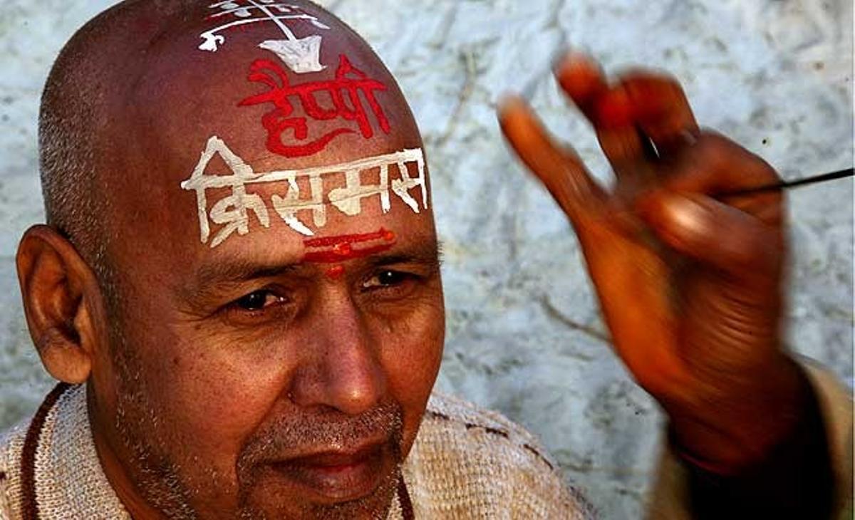 Un home té pintat al cap un missatge en hindú que diu ’bon Nadal’, a la riba del riu Ganges la vigília de Nadal, a la ciutat d’Allahabad, al nord de l’Índia.