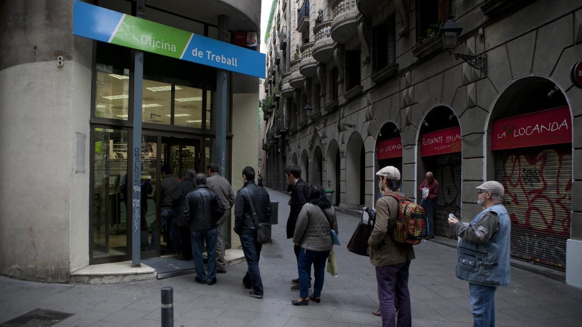 Varias personas haciendo cola frente a una oficina del Servei d’Ocupació de Catalunya (SOC).