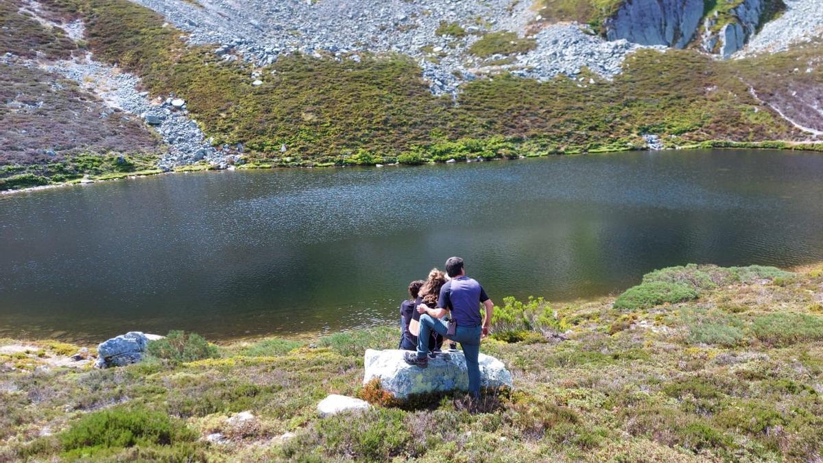 Miguel Capellín, junto a dos senderistas, al lado del lago Ubales.