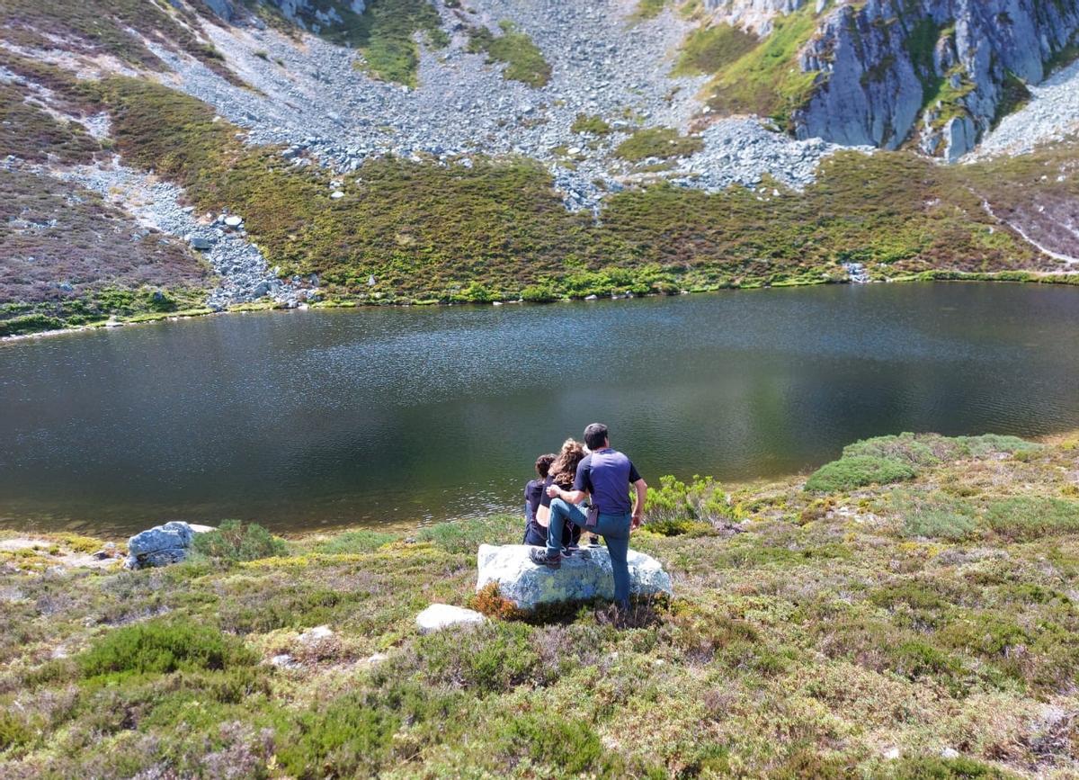 Miguel Capellín, junto a dos senderistas, al lado del lago Ubales.