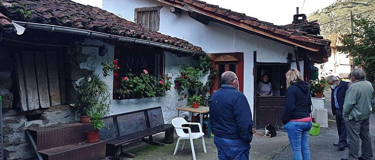 La alcaldesa de Ponga, Marta Alonso, de espaldas, habla con los vecinos sobre su confinamiento.