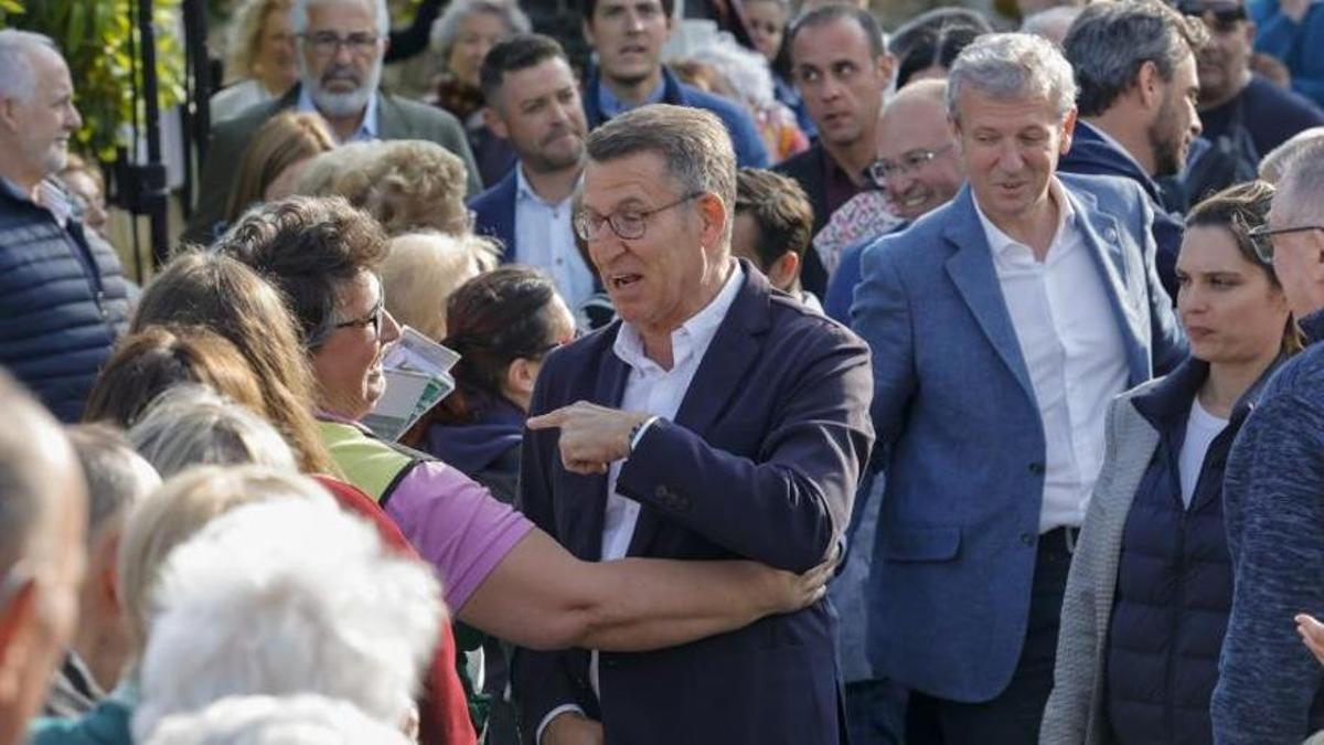 Feijóo, en centro y con Rueda detrás, saluda a una simpatizante antes de ofrecer un mitin en Ferrol.