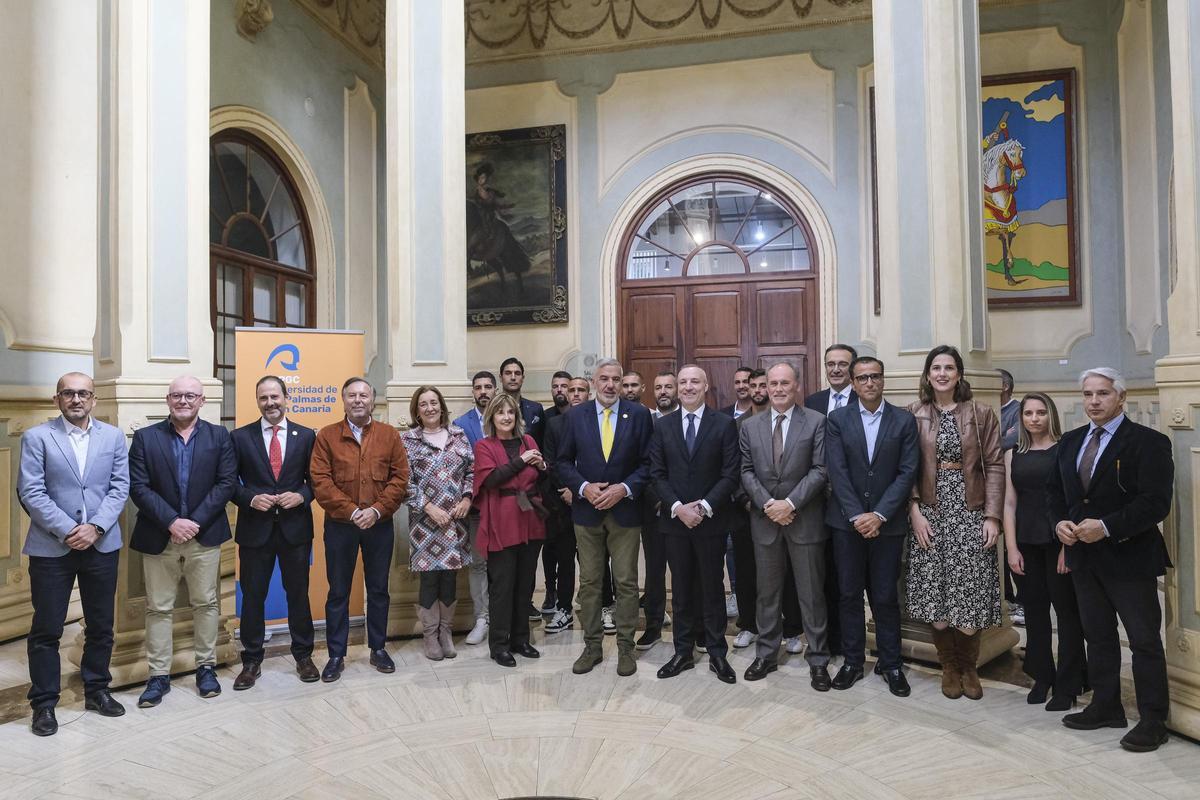 Foto de familia de los presentes en el acto en la ULPGC con los estudiantes galardonados de las Becas DiSAFÍO, así como políticos e integrantes de la delegación amarilla.
