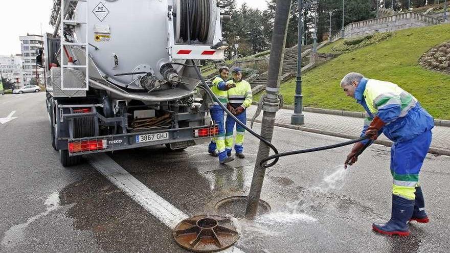 Un grupo de operarios realizando trabajos con agua en el centro de la ciudad. // Marta G. Brea