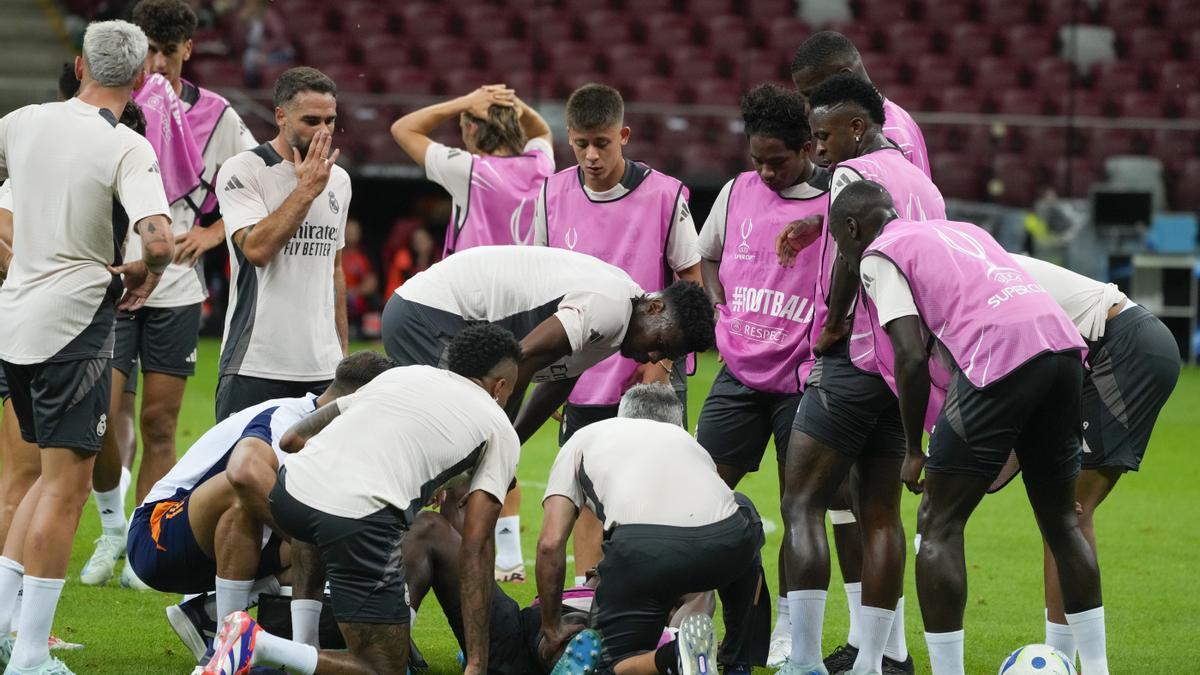 Los jugadores del Real Madrid se acercan para interesarse por el estado de Camavinga tras su lesión.