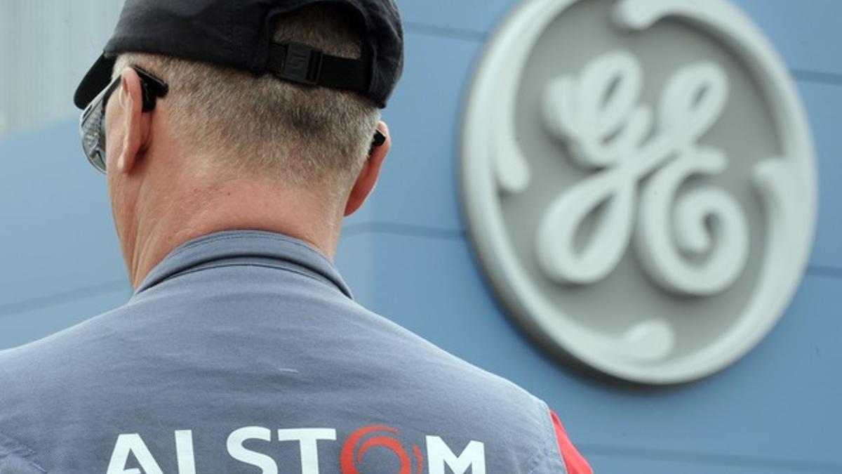 Un empleado de Alstom frente a un logo de GE, durante las negociaciones de la compra