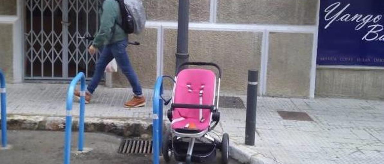 Carrito de beé estacionado en el aparcamiento de bicicletas.