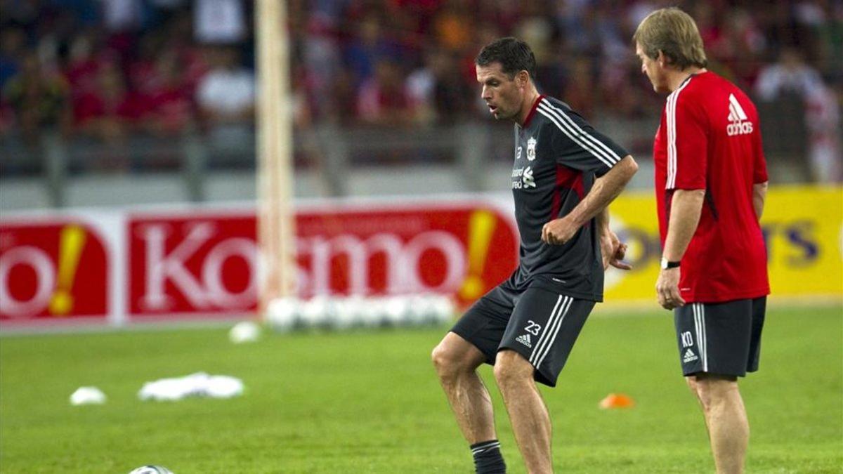 Kenny Dalglish charla con Jamie Carragher durante su estancia en el banquillo del Liverpool