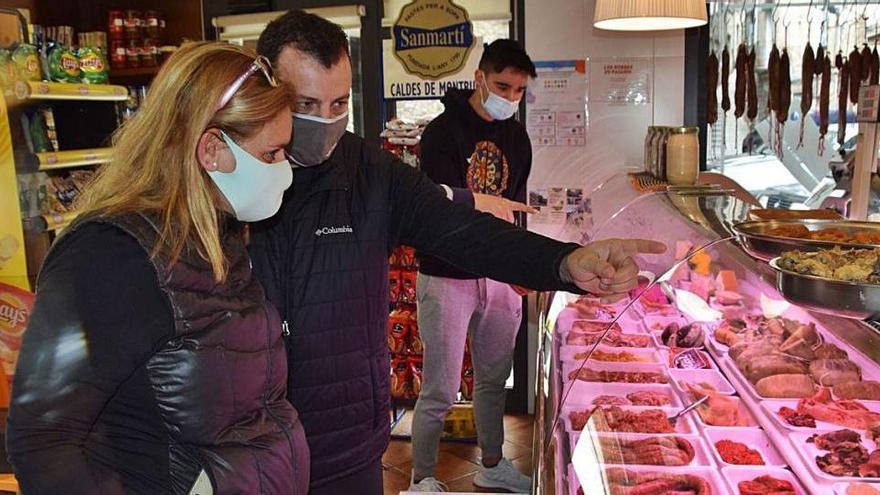 A l&#039;esquerra, clients de la cansaladeria Falgàs de la Pobla de Lillet. A la dreta, la propietària del negoci familiar Calçats Benito, sense clients