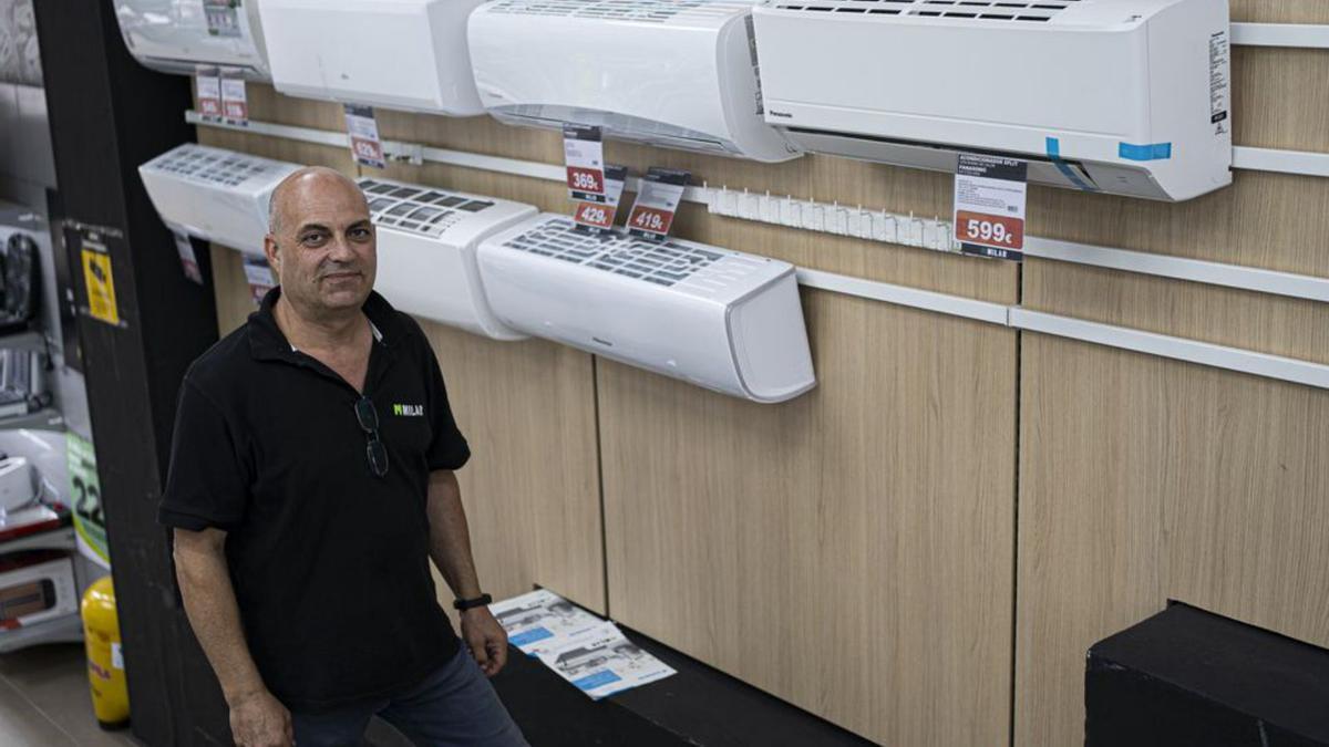 El encargado Carlos Moya junto a la exposición de aires acondicionados en la tienda Milar. 