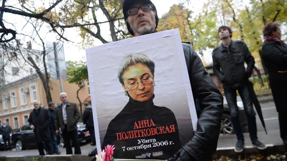 Un hombre sostiene una foto de Politkóvskaya en una concentración en su recuerdo el viernes en Moscú.