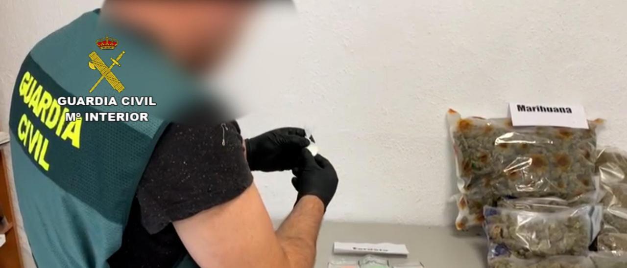 Un agente de la Guardia Civil con la droga intervenida en la operación.