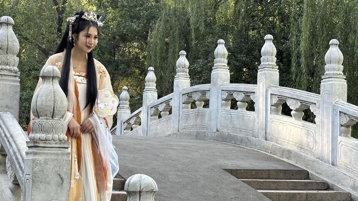 Una mujer se fotografía en un puente del antiguo palacio de verarno en PekÍn.