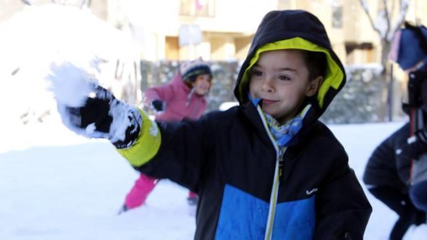 Un nen jugant amb la neu en una escola de Vic, ahir al matí