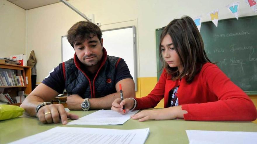 Juan Miguel Molinero revisa un trabajo con la alumna Irene Moreno en el colegio Teodoro Cuesta.