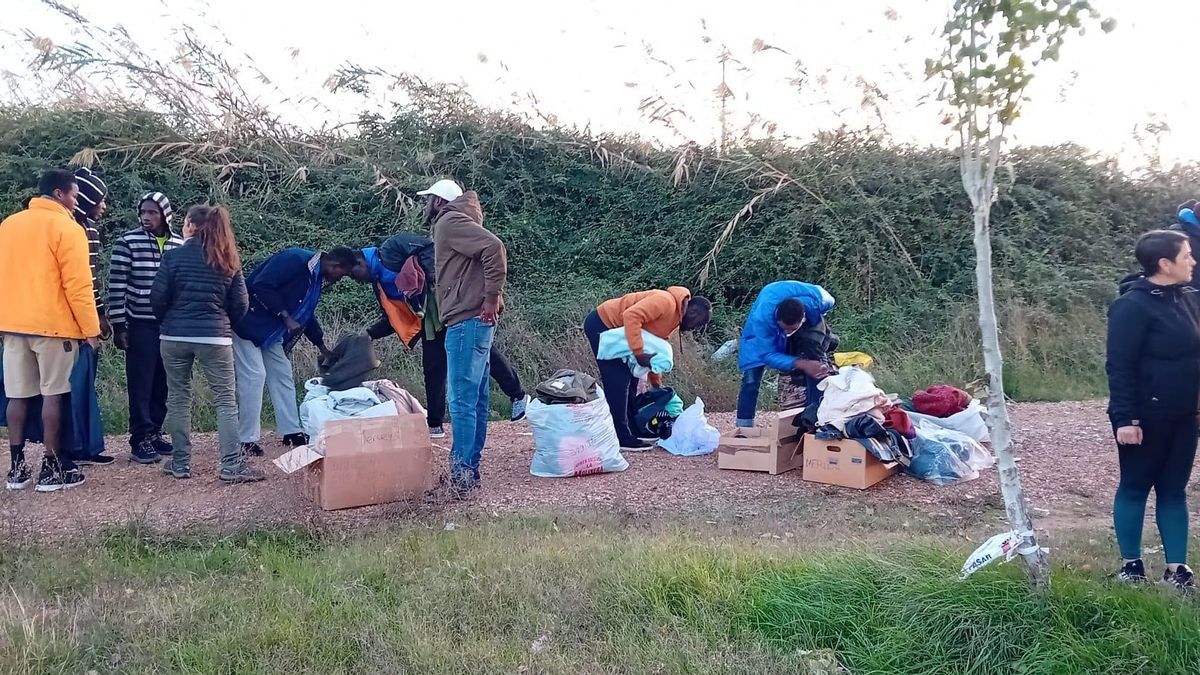 Voluntarios de la plataforma entregándole ropa a los migrantes.