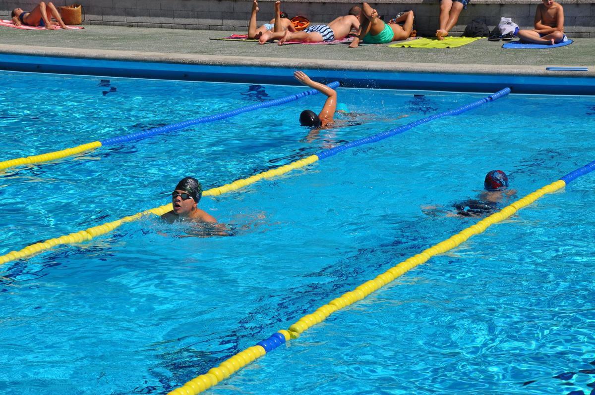 Usuarios nadando en la piscina municiapal de O Milladoiro.