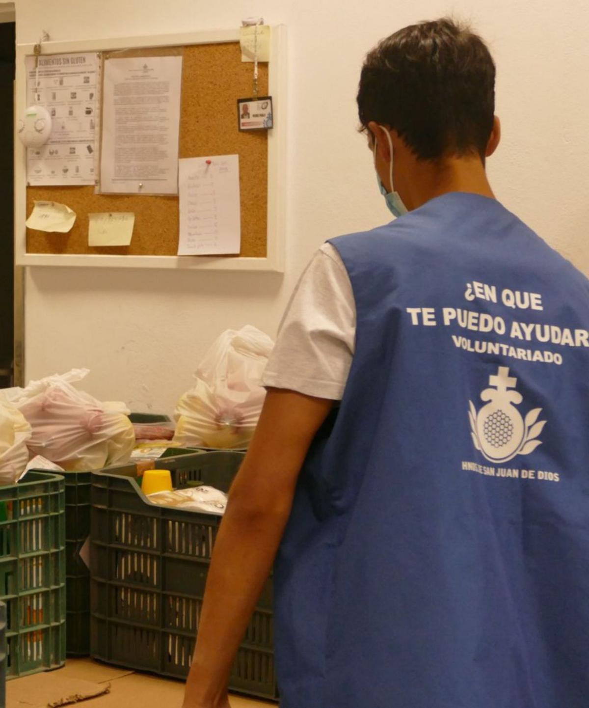 Un voluntario prepara cajas de alimentos para los más desfavorecidos.