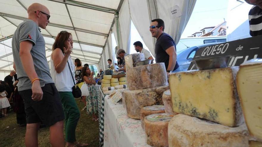 Visitantes ante uno de los puestos queseros en el certamen de Panes, en Peñamellera Baja.