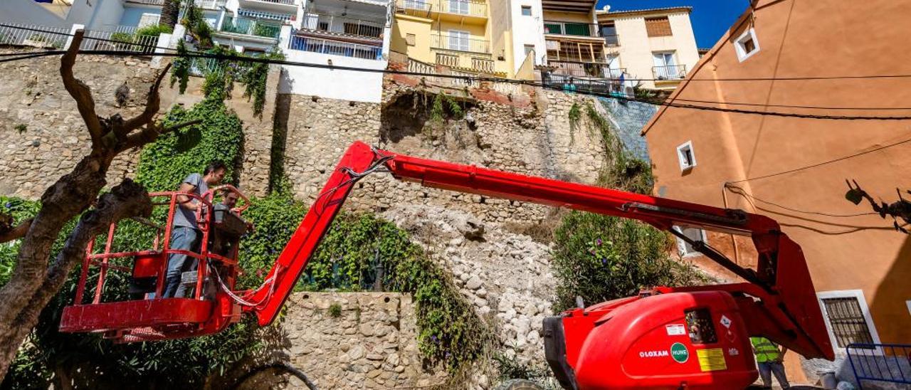 Los operarios de la empresa que realizará las obras de emergencia, ayer en la zona donde cayeron las piedras del muro de la calle Pal.