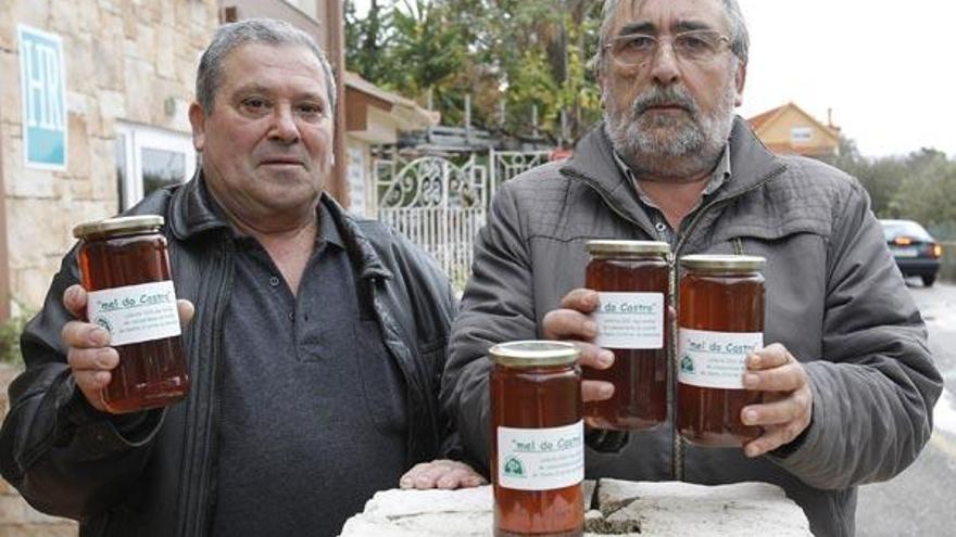 Raúl González y Xosé Alfredo Pereira, directivos de la comunidad de montes de Santa Cristina, muestran los primeros frascos de miel comunal &quot;O Castro&quot;.  // Ricardo Grobas