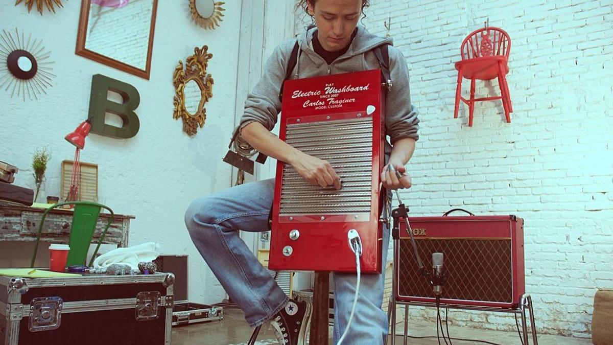 Carlos Traginer, tocando la tabla de lavar eléctrica que él mismo creó.