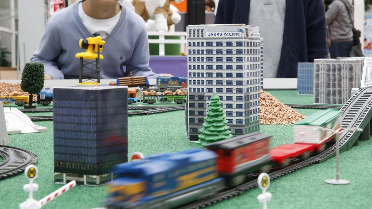 Uns xiquets, davant un tren de joguet.